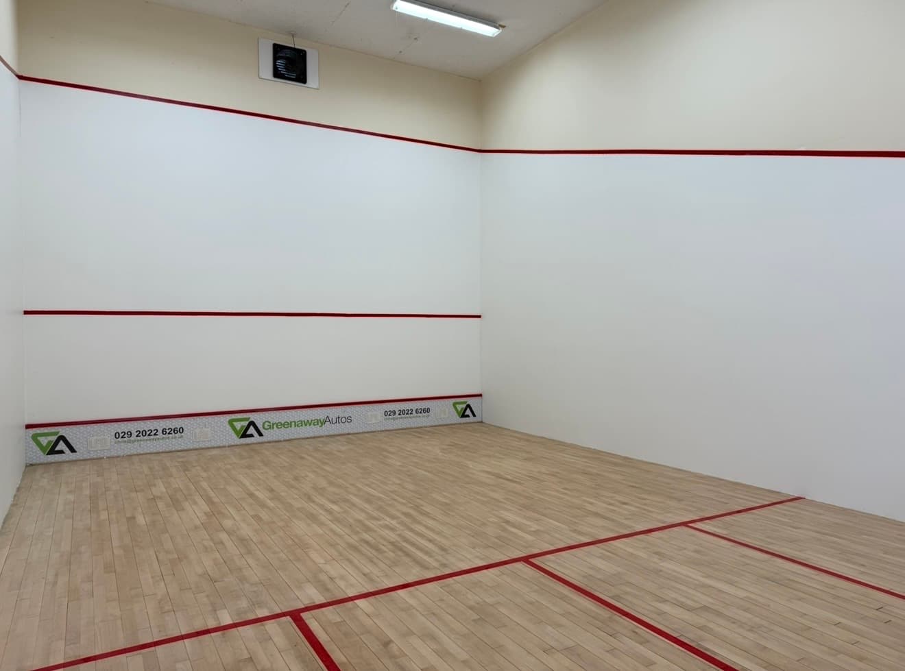 A squash court freshly repainted in clean court white