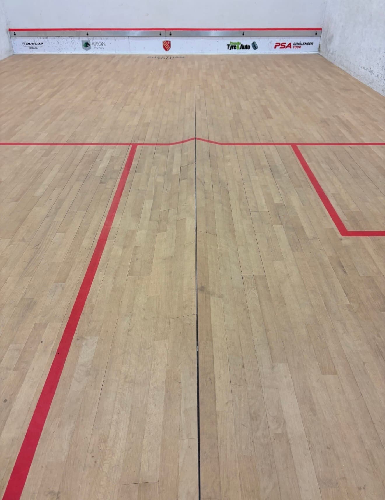 Split and lifted squash court floorboards before repair